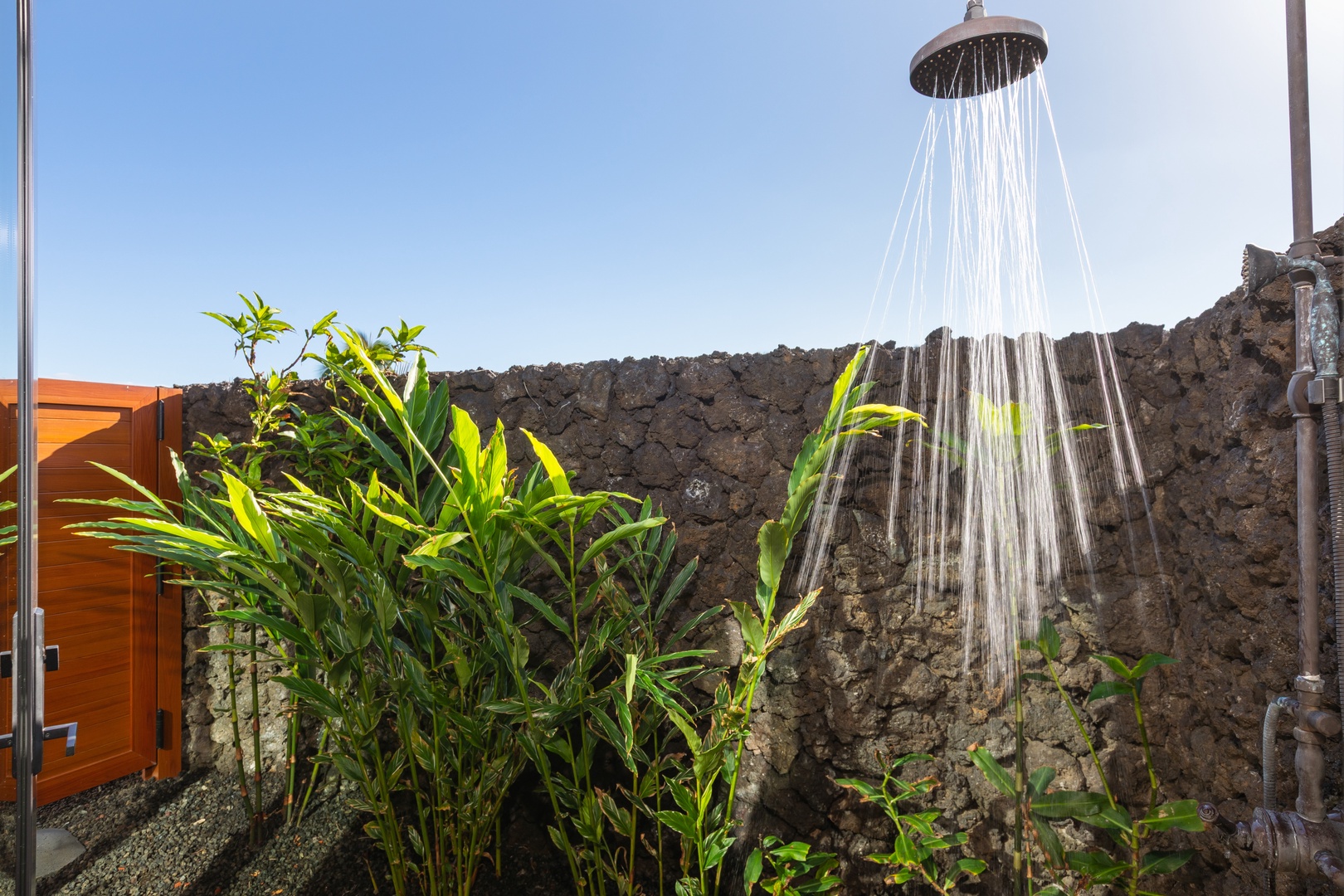 Kamuela Vacation Rentals, 5BD Mauna Lani Lux Ocean Estate (OE12) at One Ocean - Step into your private outdoor shower sanctuary, where tropical plants and stone walls create a spa-like retreat under the open sky.