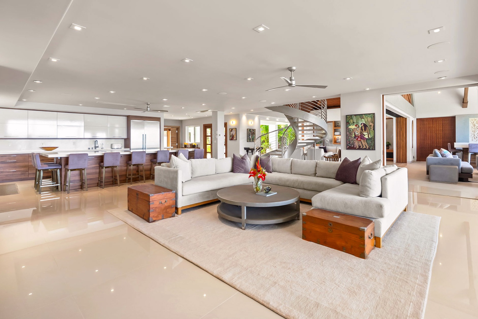 Honolulu Vacation Rentals, Diamond Head Beachfront Estate - Unwind in this bright, open-concept living space where modern elegance meets comfort. Plush seating, a spiral staircase, and a fully equipped kitchen invite you to relax and feel right at home.