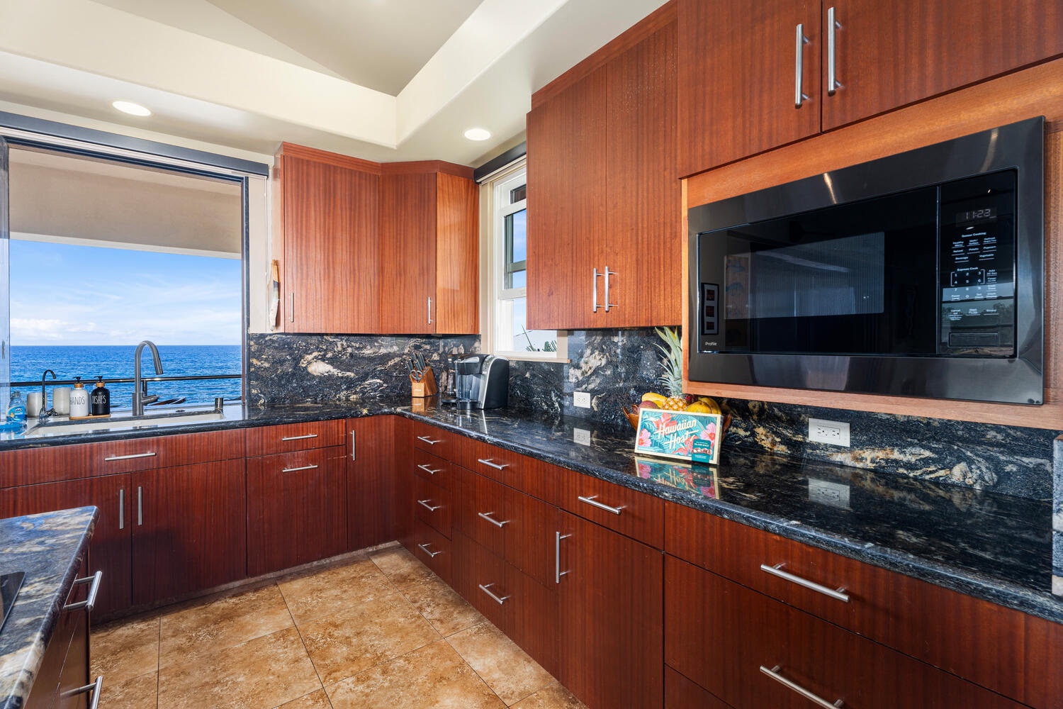 Kailua Kona Vacation Rentals, Kailani Vista - Rich koa-tone cabinetry, five-burner cooktop, and granite counters make prepping poke bowls a pleasure—plus the sea is always in sight.