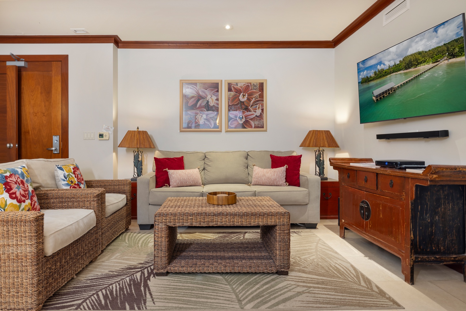 Kapolei Vacation Rentals, Ko Olina Beach Villas B506 - Unwind in your elegantly furnished living space with tropical wicker seating, vibrant artwork, and modern entertainment center for perfect vacation relaxation.
