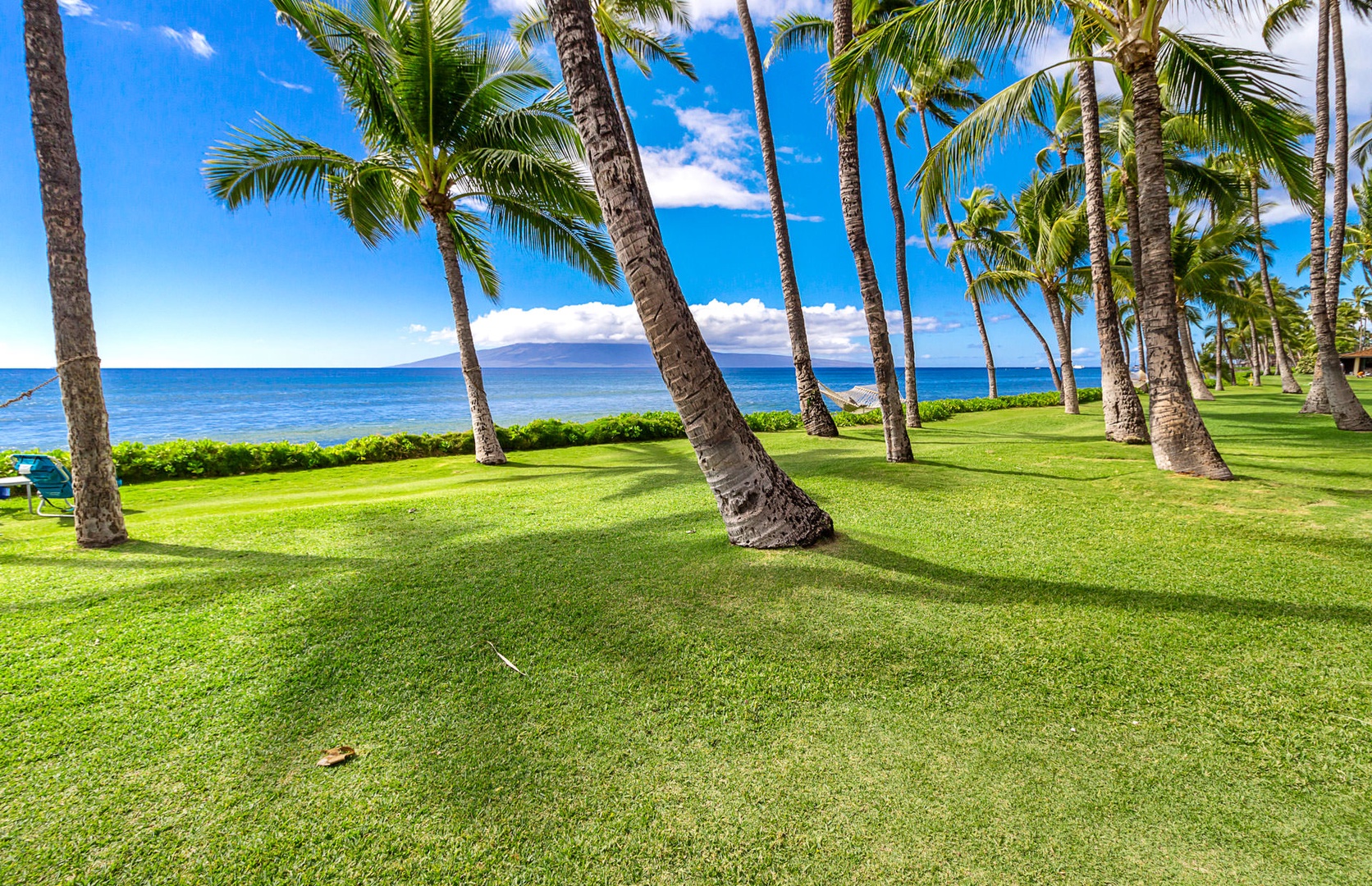 Lahaina Vacation Rentals, Puamana 240-3 - Gaze out at the tranquil shoreline, where waves meet the lush landscape.