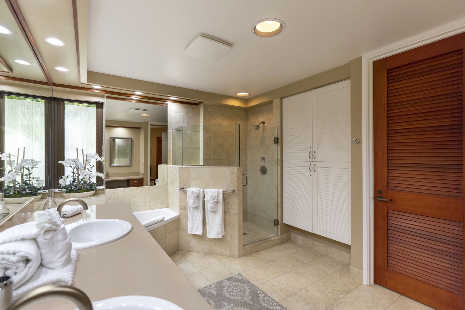 Kamuela Vacation Rentals, Mauna Lani Point E105 - The primary bath offers a walk-in shower with bench, large soaking tub, double sink vanities, and a seated makeup vanity.