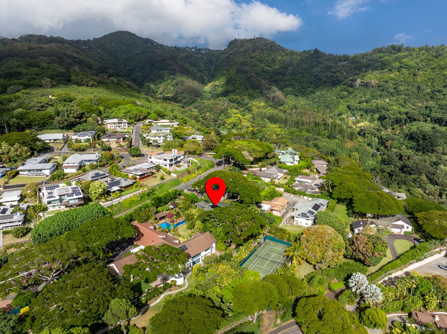 Honolulu Vacation Rentals, Tantalus Glass House (3 BD) - Aerial view of Tantalus Glass House nestled in lush hillside greenery, showcasing its private setting, surrounding tropical landscape, and proximity to Honolulu below.