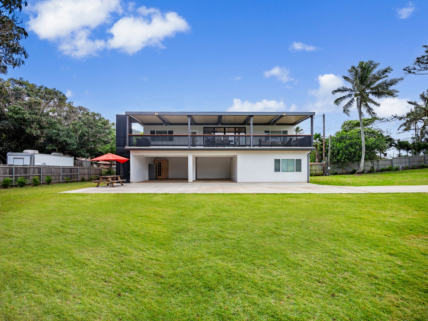 Haleiwa Vacation Rentals, Sunset Beach Island Retreat - This modern two-story home boasts a spacious yard, perfect for outdoor activities or relaxation. The expansive upper deck offers a shaded space to enjoy the breeze.