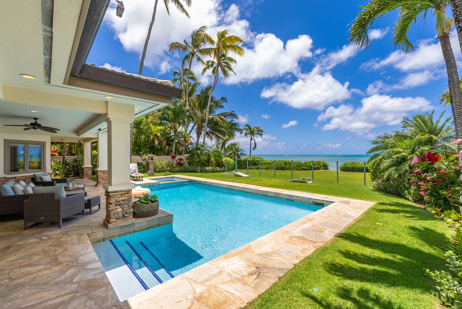 Honolulu Vacation Rentals, Maunalua Estate - Lounge beside the sparkling pool as trade winds and tropical greenery surround the shoreline.