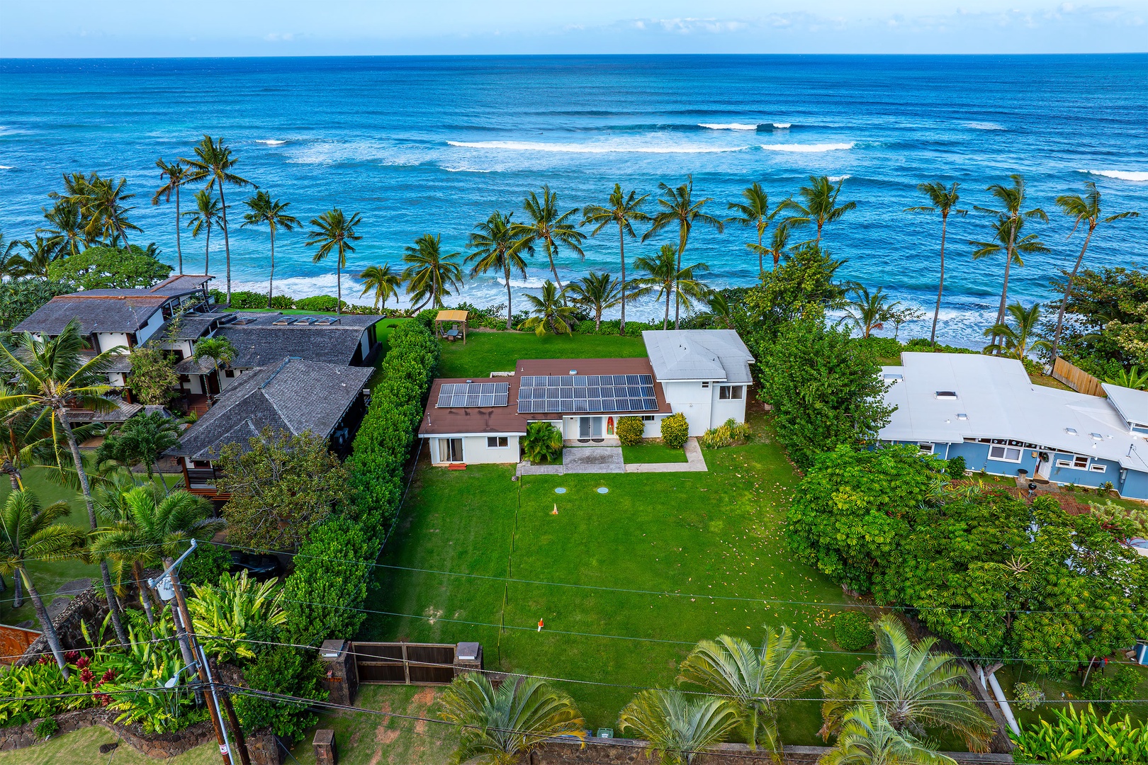 Haleiwa Vacation Rentals, North Shore Beachfront Retreat - Aerial view of the property showcasing lush greenery and proximity to the ocean.