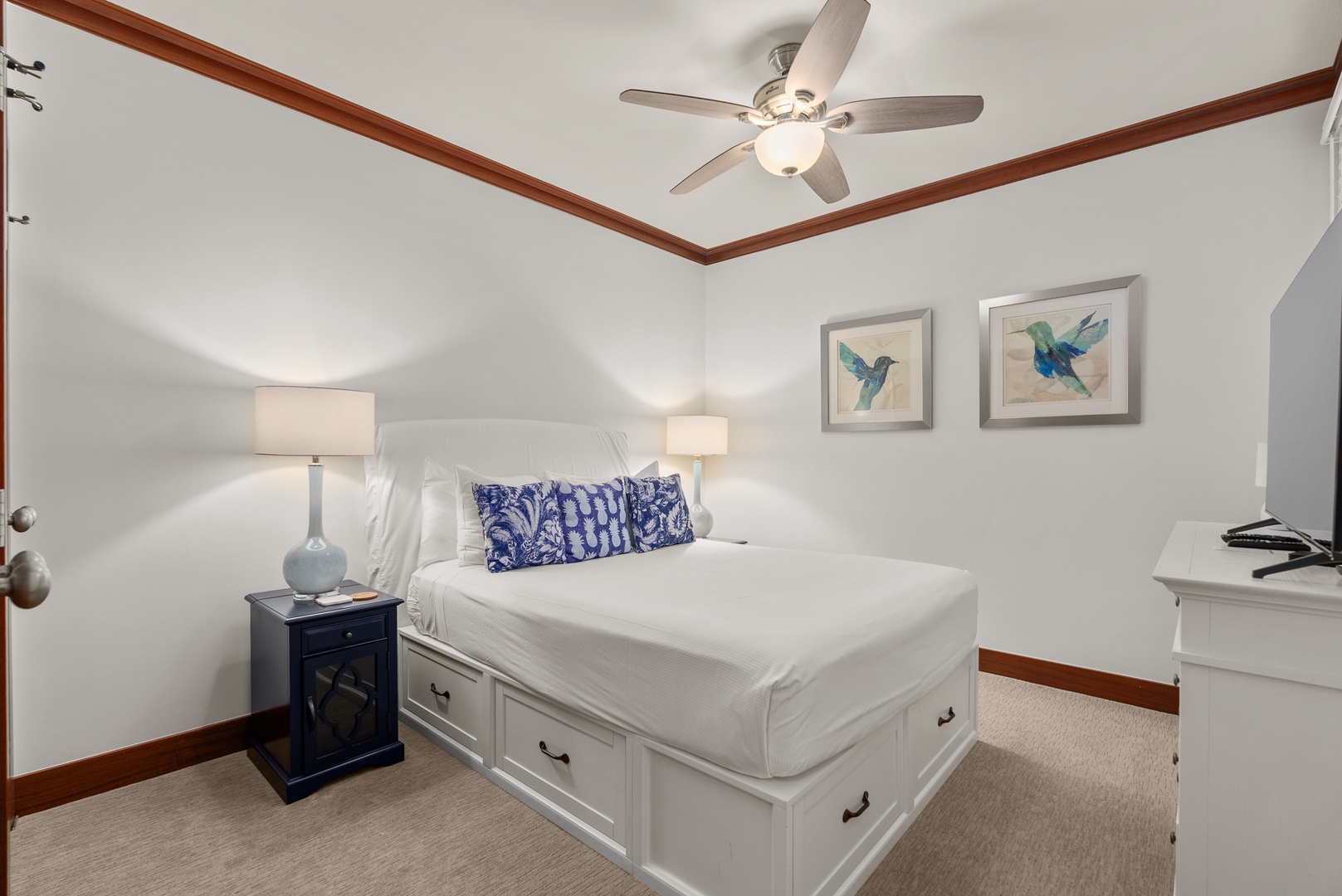 The queen bedroom offers a cool, comfortable retreat with a ceiling fan and soft lighting.