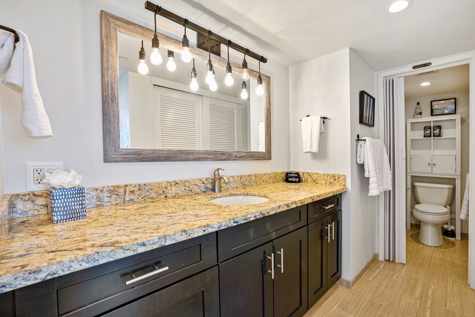 Lahaina Vacation Rentals, Valley Isle 804 - The bathroom showcases a sleek and modern design, with a spacious granite countertop and elegant lighting fixtures