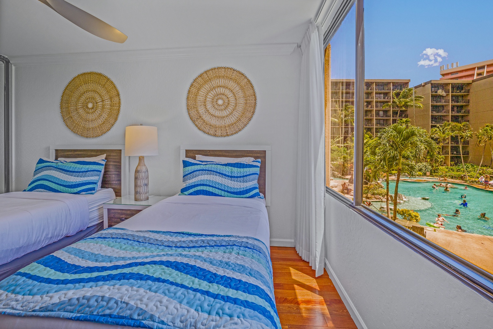 Lahaina Vacation Rentals, Kaanapali Shores 213 - A bright bedroom with twin beds that can be converted to a king-sized bed, large windows, and a stunning view of the pool