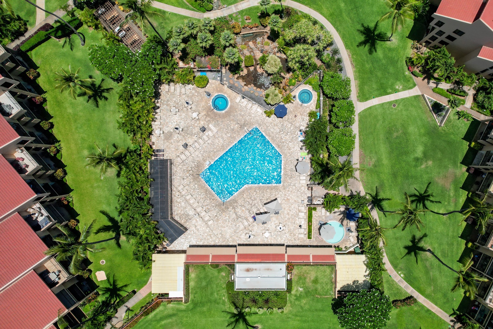 Kihei Vacation Rentals, Kamaole Sands 5310 - From above, the community pool and its two round hot tubs share one deck ringed by palm shadows.