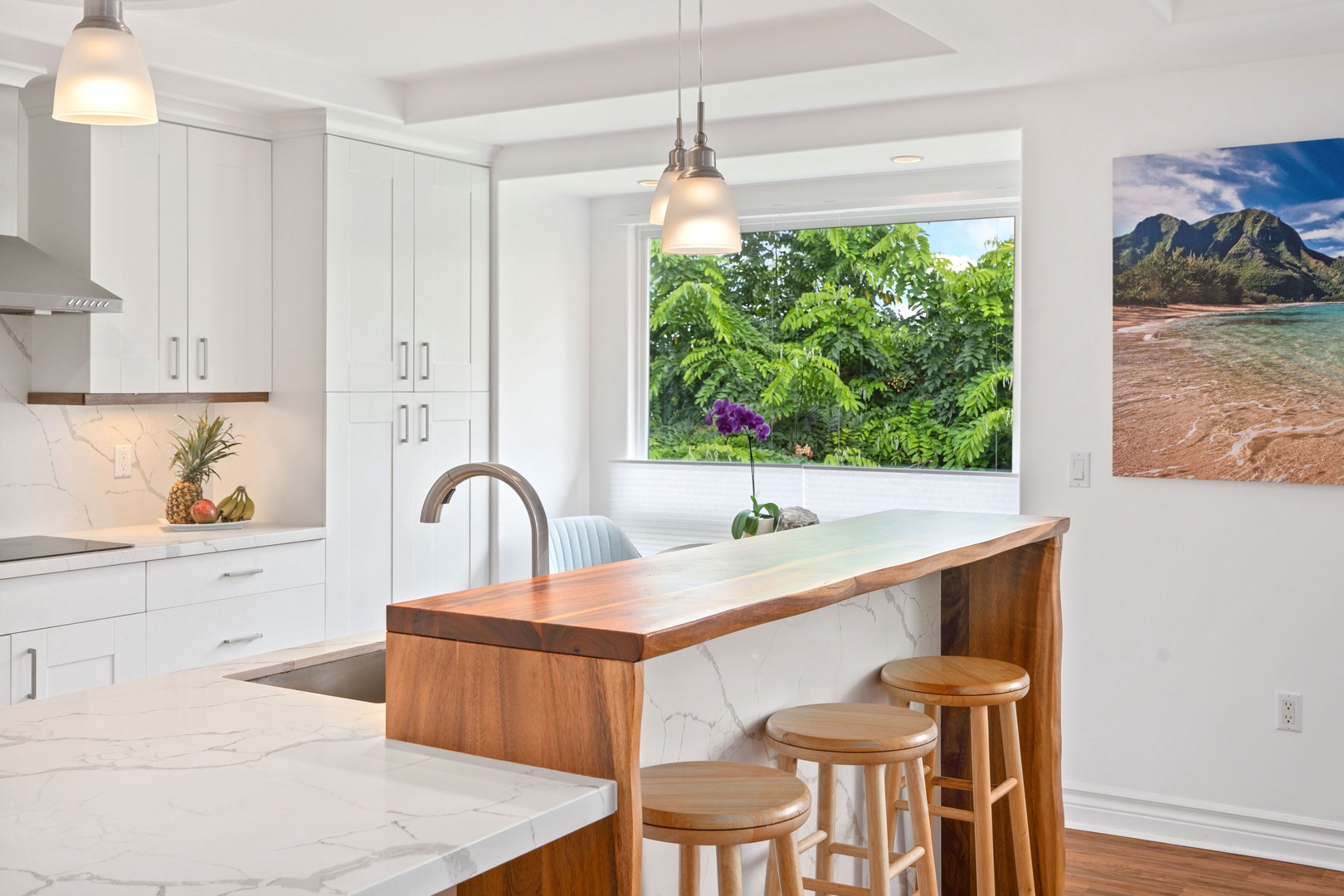 Princeville Vacation Rentals, Tropical Elegance - Modern kitchen with bar seating, ideal for vacation breakfasts and gatherings.