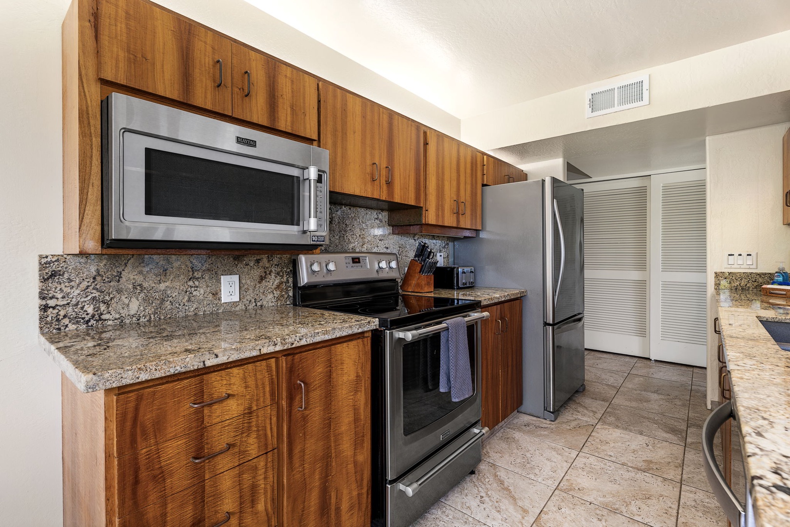 Kailua Kona Vacation Rentals, Kanaloa at Kona 1606 - A full run of counters, stainless appliances, and warm wood cabinetry, ready for a real meal.