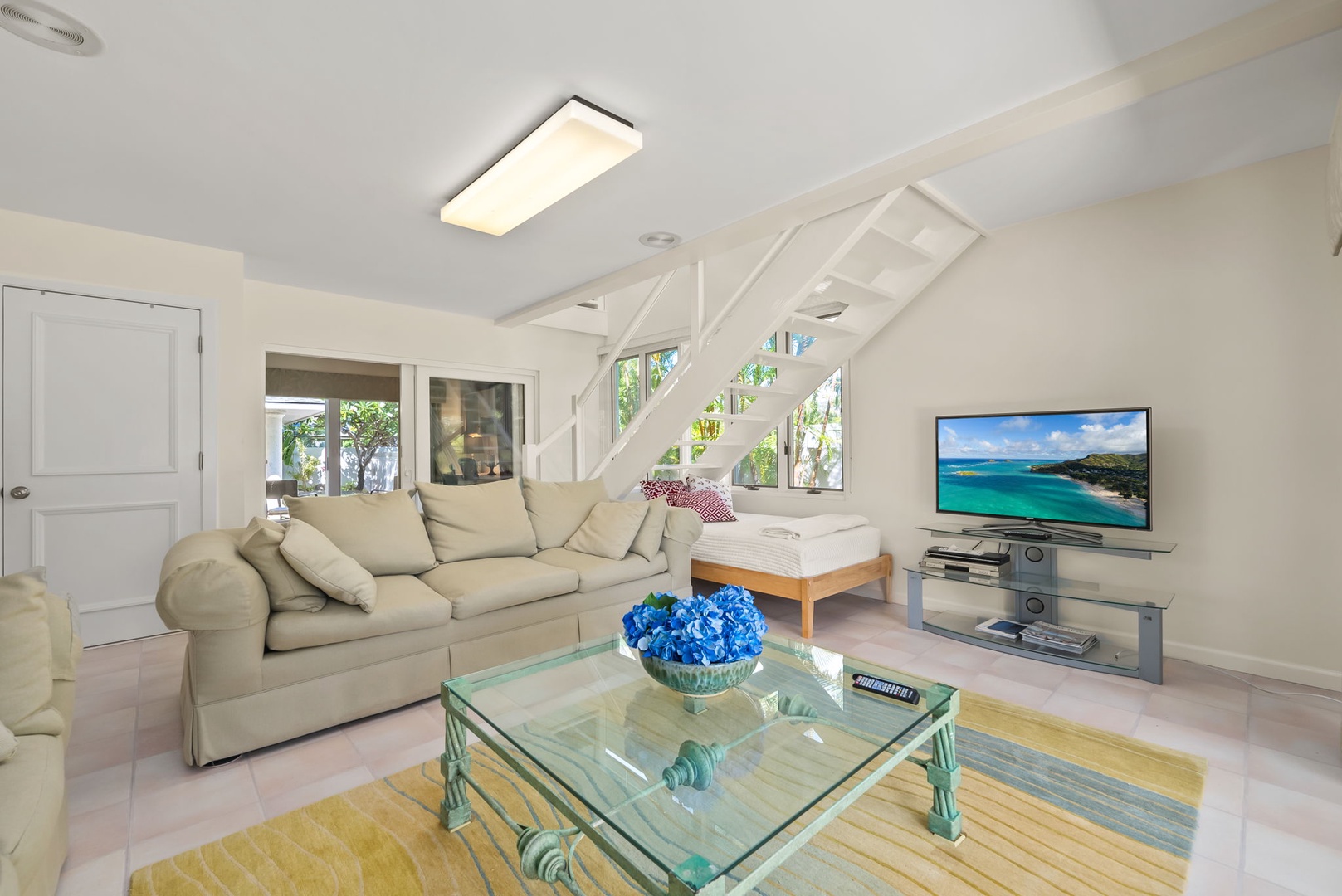 Honolulu Vacation Rentals, Kahala Oasis - Comfortable family den with modern furnishings and a glass coffee table, designed for relaxation.