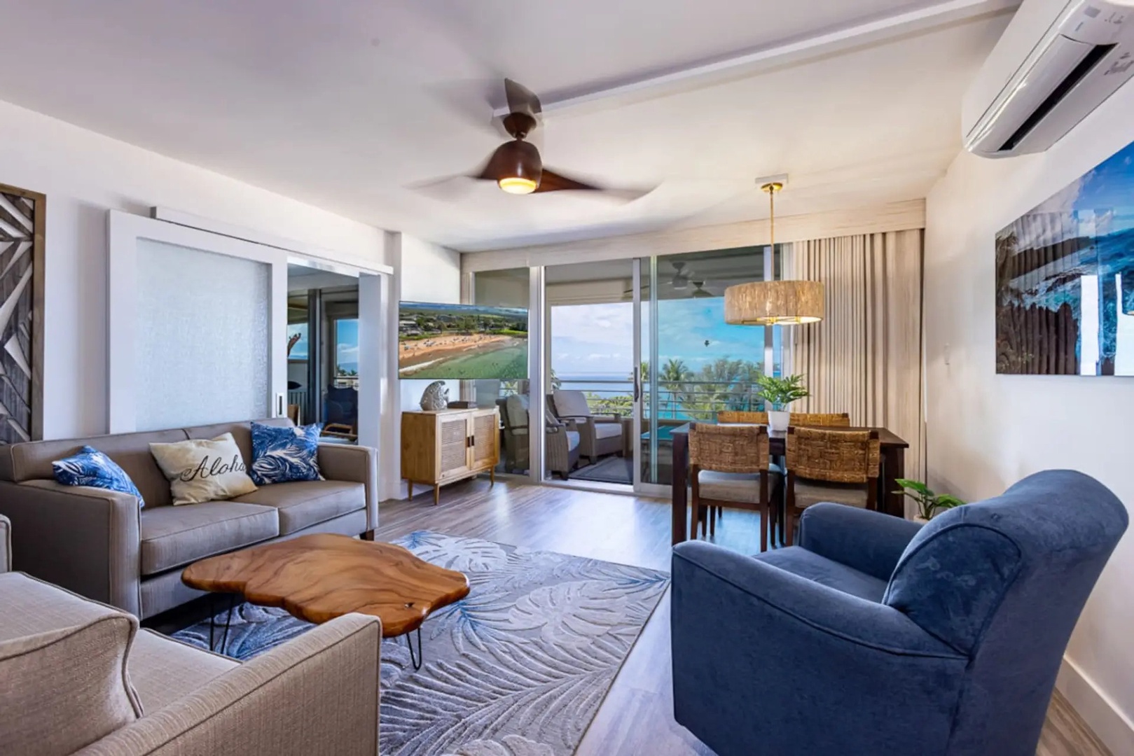 Kihei Vacation Rentals, Kamaole Beach Royal 610 - A blue accent chair and gray sofa give the living room its own quiet corner near the sliders.