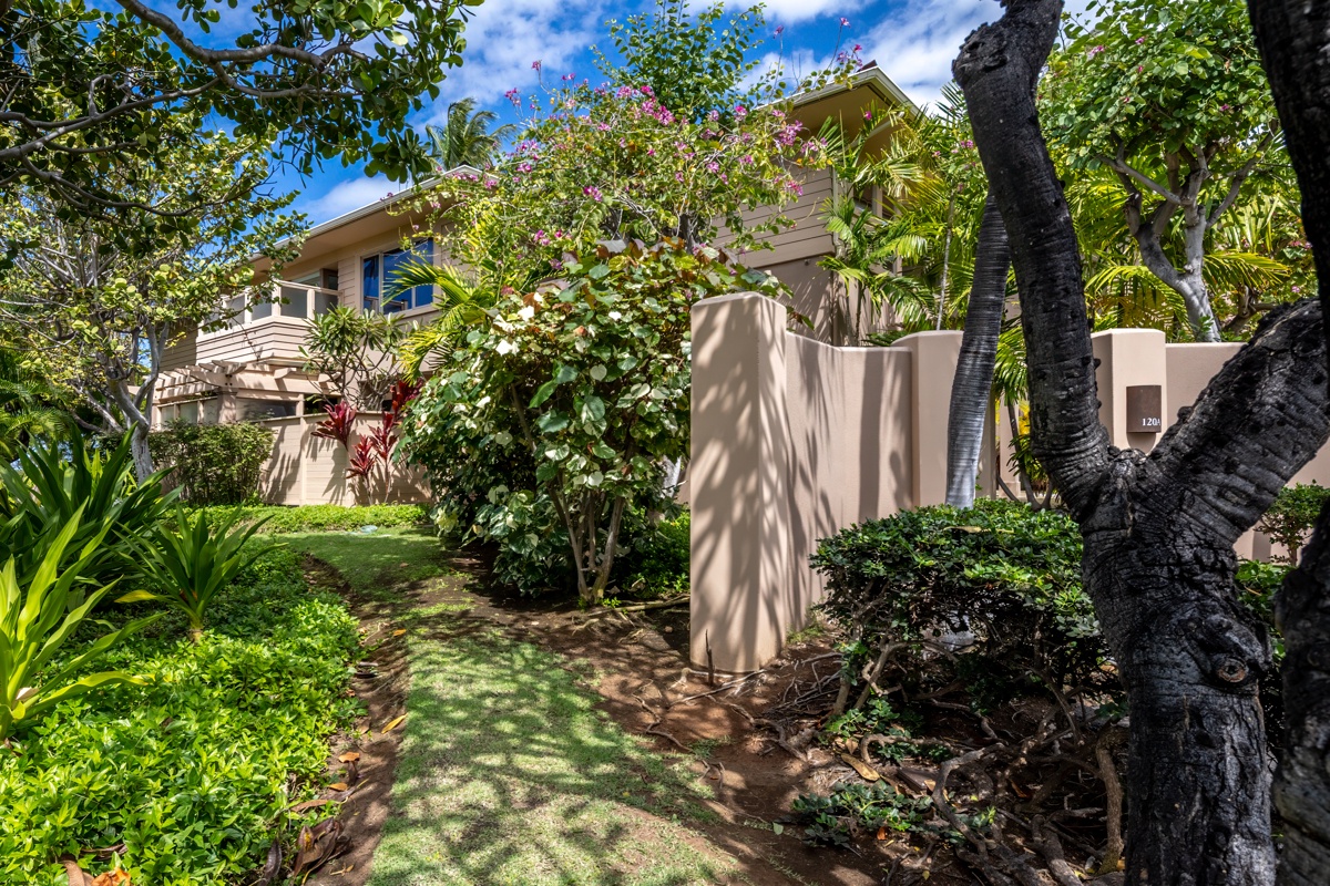 Kailua Kona Vacation Rentals, Fairways Villa 120A - Tropical property surrounded by lush gardens with vibrant bougainvillea and swaying palms creating a serene island atmosphere.