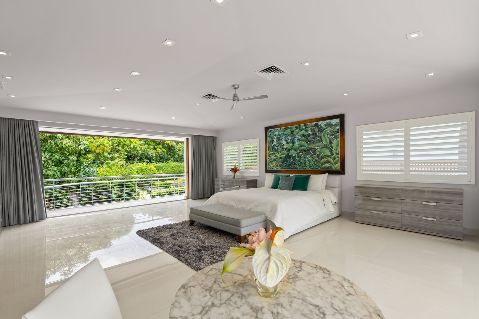 Honolulu Vacation Rentals, Diamond Head Beachfront Estate - Step into your serene bedroom retreat, where a plush king bed awaits beneath artwork that celebrates tropical beauty. Slide open the glass doors to your private balcony overlooking lush greenery, and unwind in modern comfort.