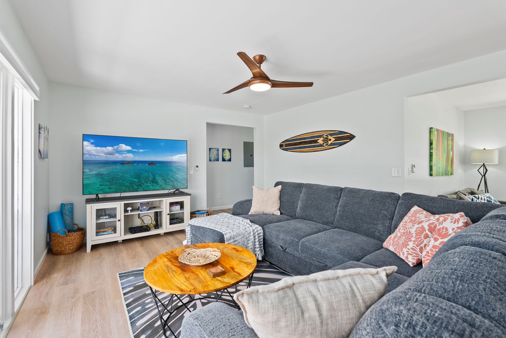 Kailua Vacation Rentals, Hale Alapi'i Lanikai Getaway - Settle into this inviting living room, equipped with a cozy sofa and large TV, perfect for movie nights or simply enjoying the serene views from the nearby windows.