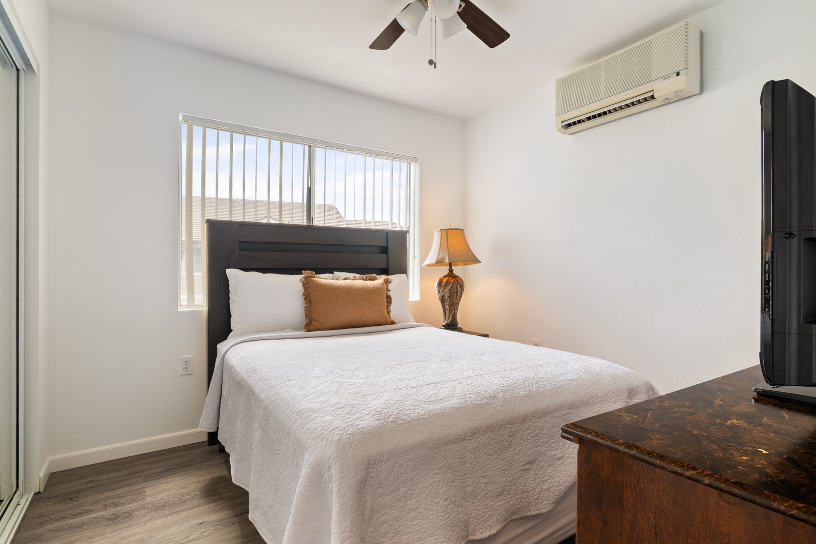 Kapolei Vacation Rentals, Fairways at Ko Olina 7A - Drift off in this peaceful bedroom with crisp white linens, warm natural light, and modern comforts including AC and ceiling fan for perfect temperature.