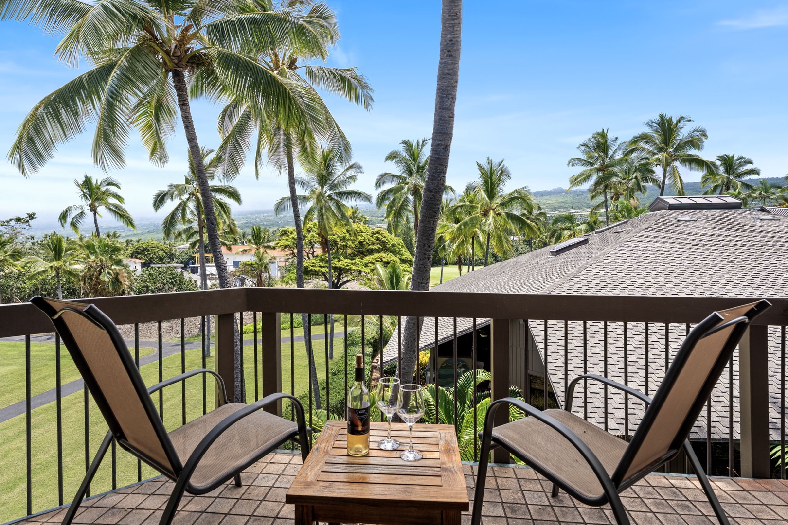 Kailua Kona Vacation Rentals, Kanaloa at Kona 1606 - Two chairs and a small table on the lanai, greens and palms in view.