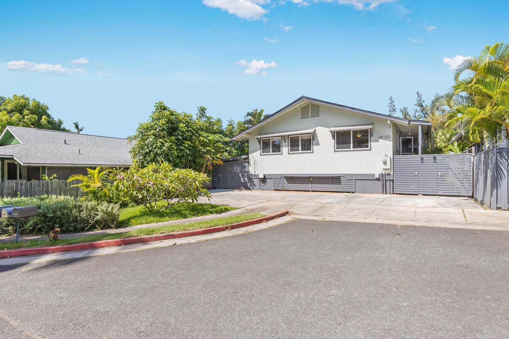 Haleiwa Vacation Rentals, Velzey Villa (3B Vacation Home) - Bright daytime exterior view of the villa, framed by tropical greenery.