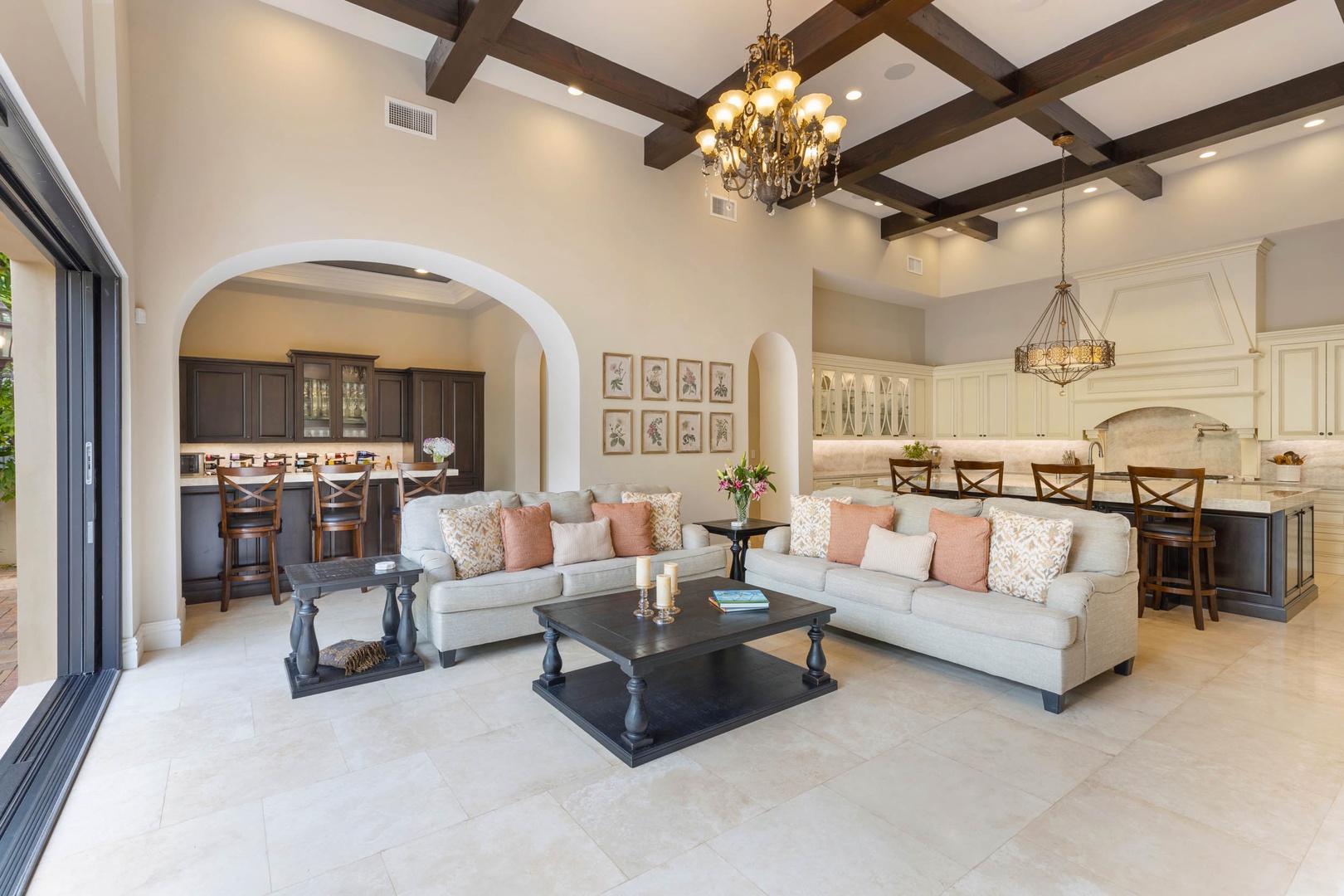 Honolulu Vacation Rentals, The Kahala Mansion Event Venue - Comfortable living room with cozy sofas, soft decor, and vaulted ceilings accented with wood beams and a chandelier.