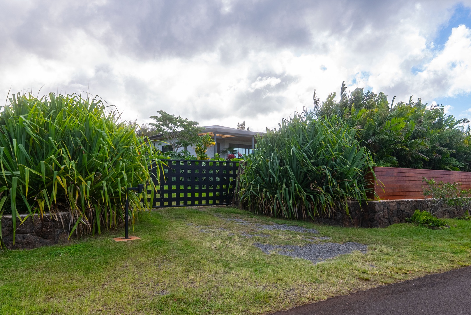 Haleiwa Vacation Rentals, Hale Mahina - Enter through a charming garden gate bordered by lush greenery and island plantings.