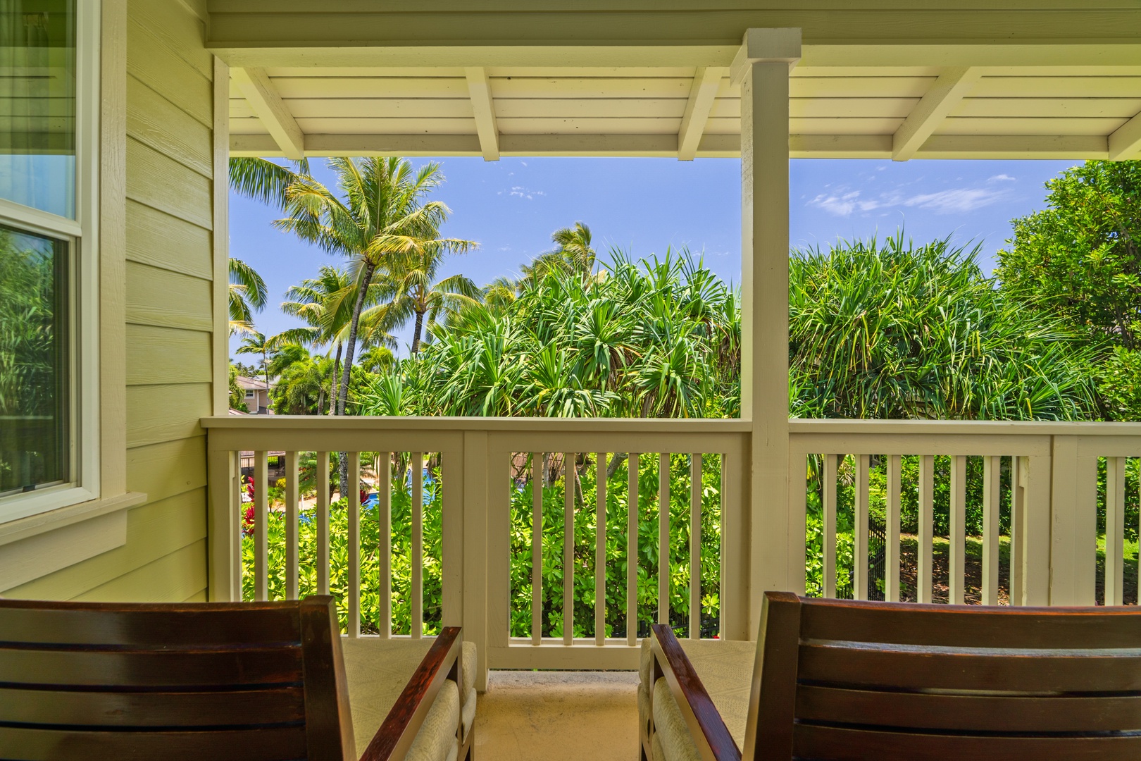 Princeville Vacation Rentals, Kaimana Villa - Relax on your lanai surrounded by lush tropical palms and vibrant greenery, where peaceful mornings begin with coffee and stunning views.