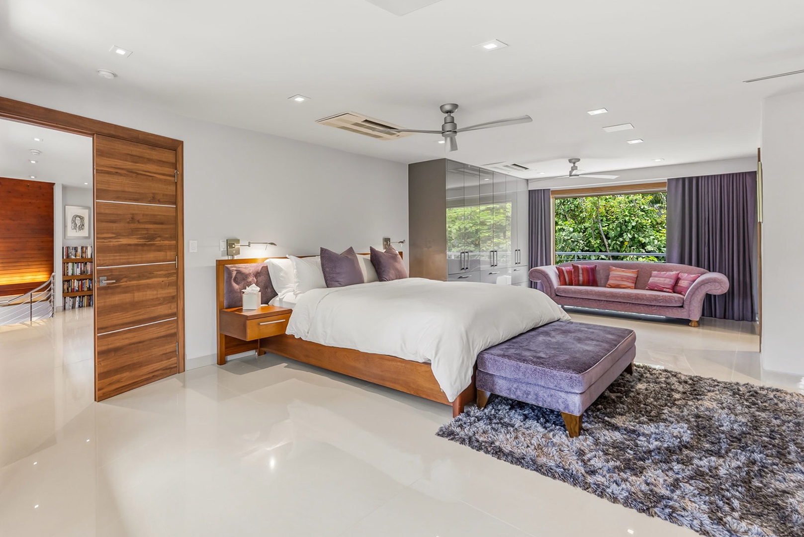 Honolulu Vacation Rentals, Diamond Head Beachfront Estate - Sink into a plush king bed with crisp linens, unwind on the velvet sofa, and wake to lush garden views through floor-to-ceiling windows—your serene retreat awaits.