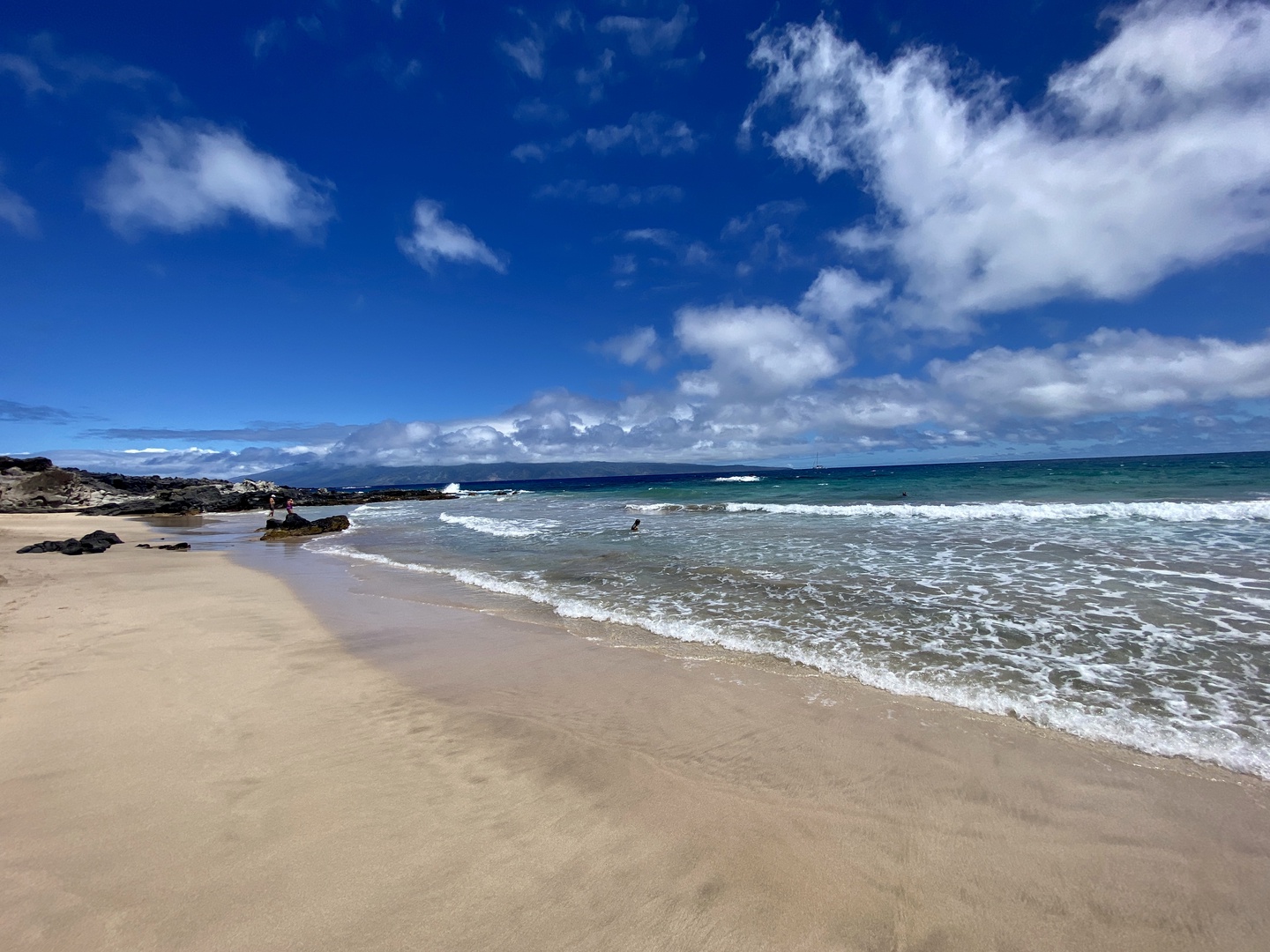 Lahaina Vacation Rentals, Kapalua Ridge 1421 - This inviting beach scene showcases soft sands and gentle waves under a bright blue sky.