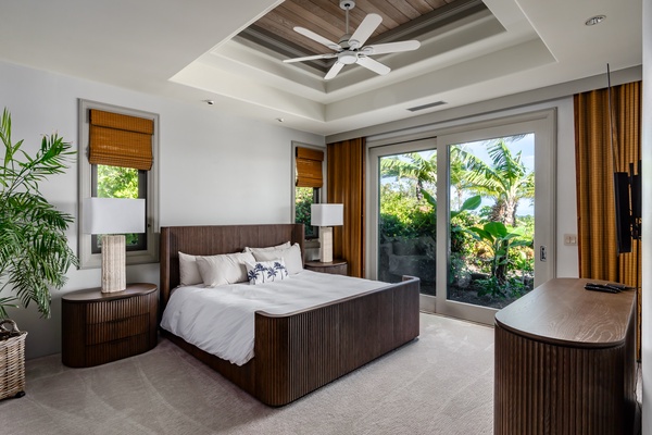 Kamuela Vacation Rentals, Canoe House & Beach Walker at Champion Ridge - Bright bedroom with a stylish king-sized bed, ceiling fan, and floor-to-ceiling windows.