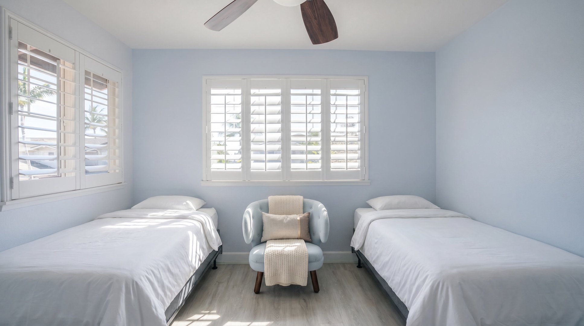Light blue walls and plantation shutters keep the twin room calm at the end of a long day.
