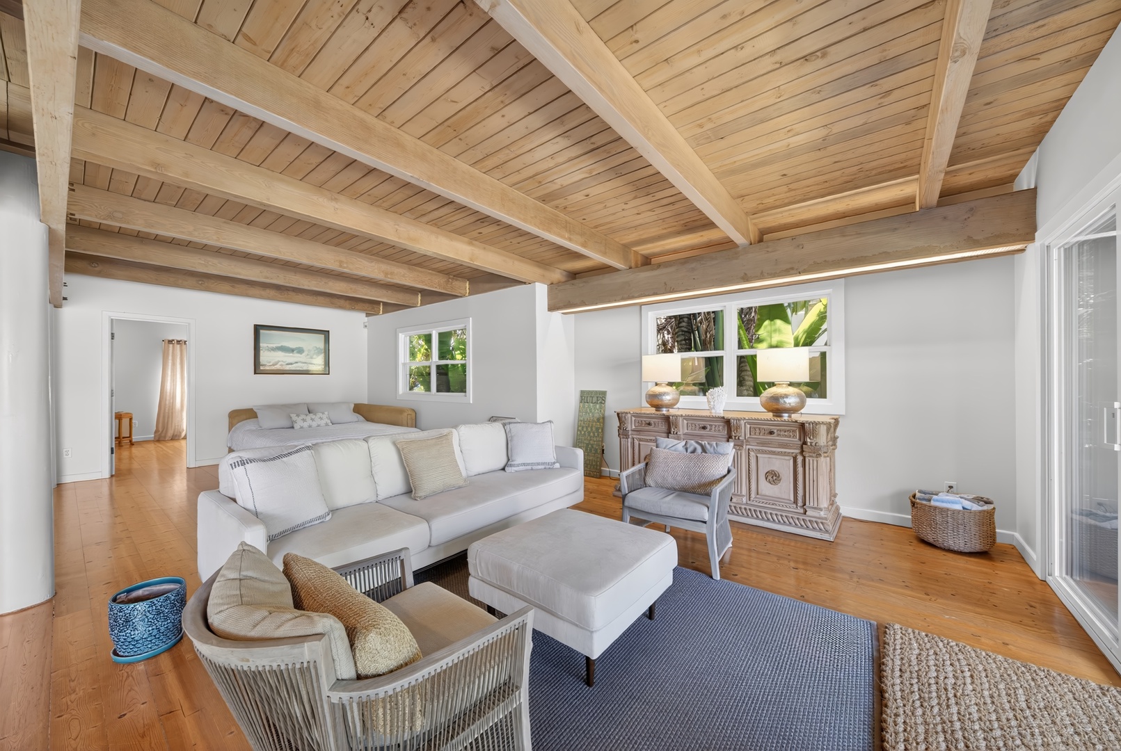Haleiwa Vacation Rentals, Sunset Beach Hideaway - Settle into your bright, airy living space with stunning vaulted ceilings and warm wood floors. Natural light pours through large windows as you relax on plush seating surrounded by coastal charm.