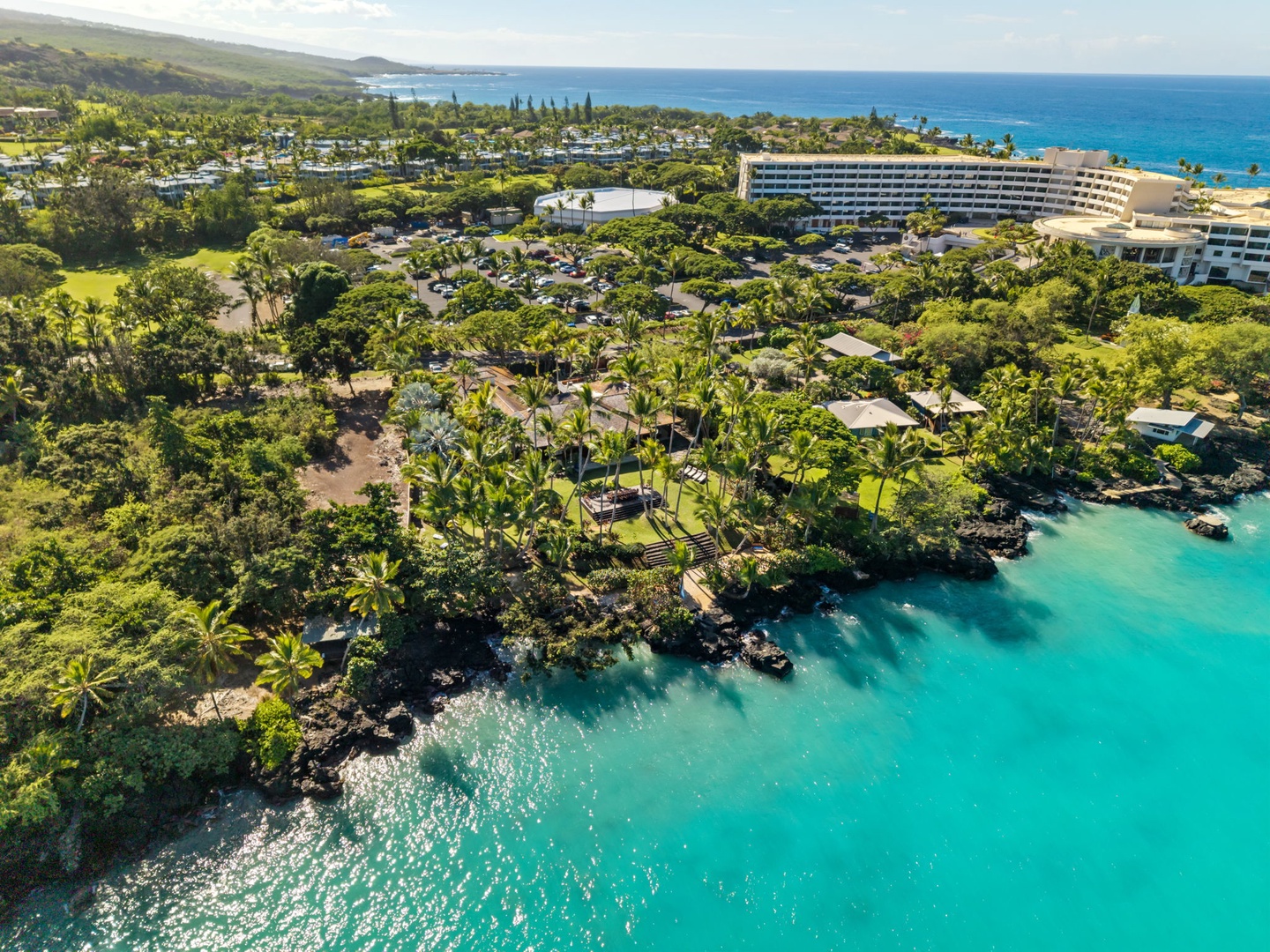 Kailua-Kona Vacation Rentals, Hahalua Bay Villa - Tropical resort nestled along pristine turquoise waters, surrounded by lush palm groves and rolling green hills.