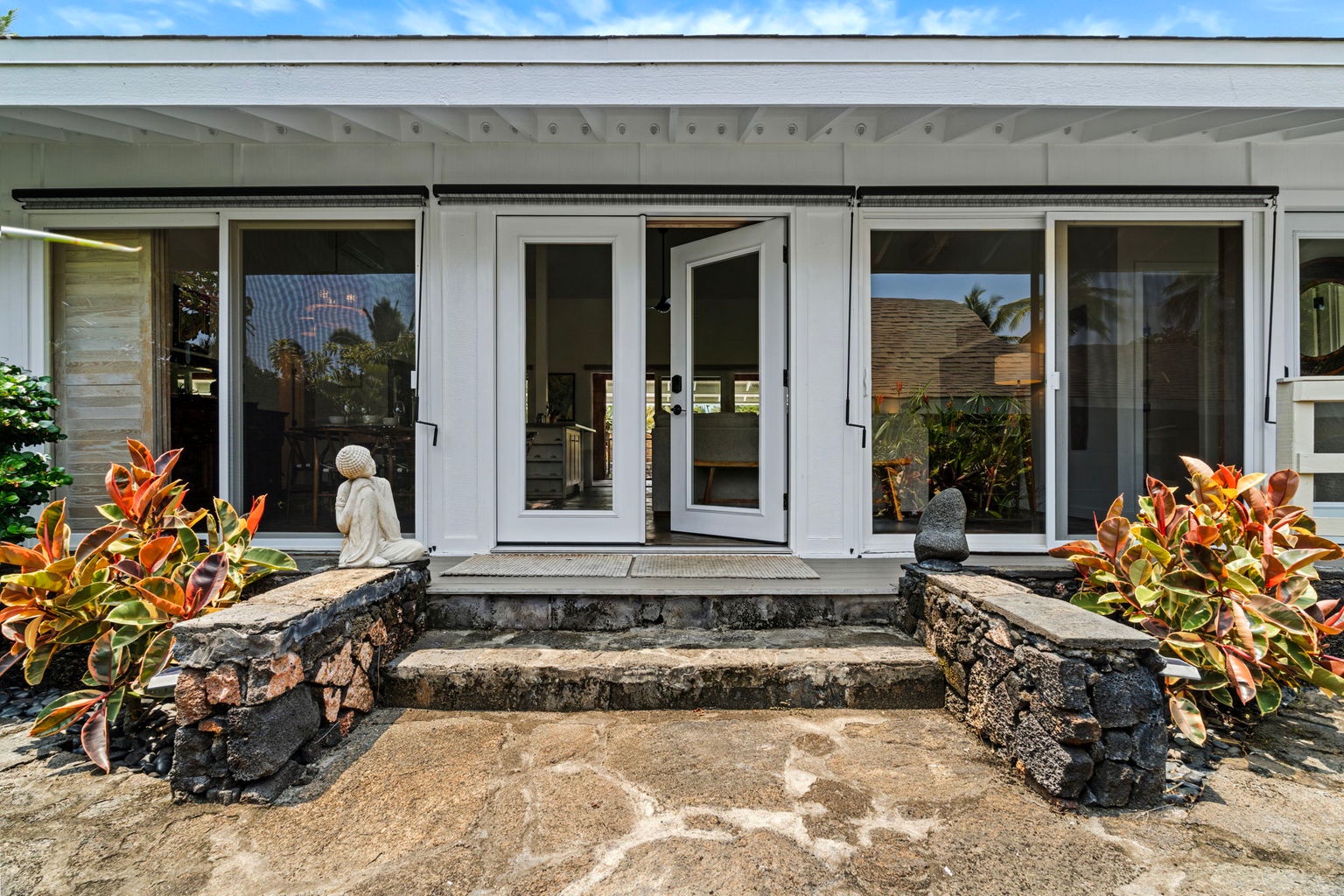Kailua Kona Vacation Rentals, Manukai Hale - French doors open onto a deck framed by tropical plantings.