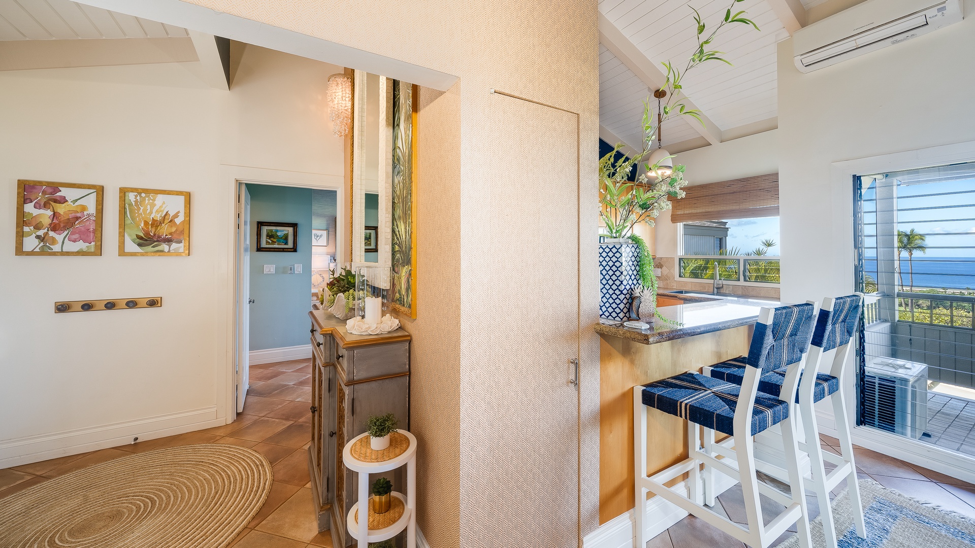 Kihei Vacation Rentals, Wailea Ekolu 1106 - A cozy kitchen corner with bar seating, offering a relaxed spot for quick meals or morning coffee while overlooking the tropical views outside.