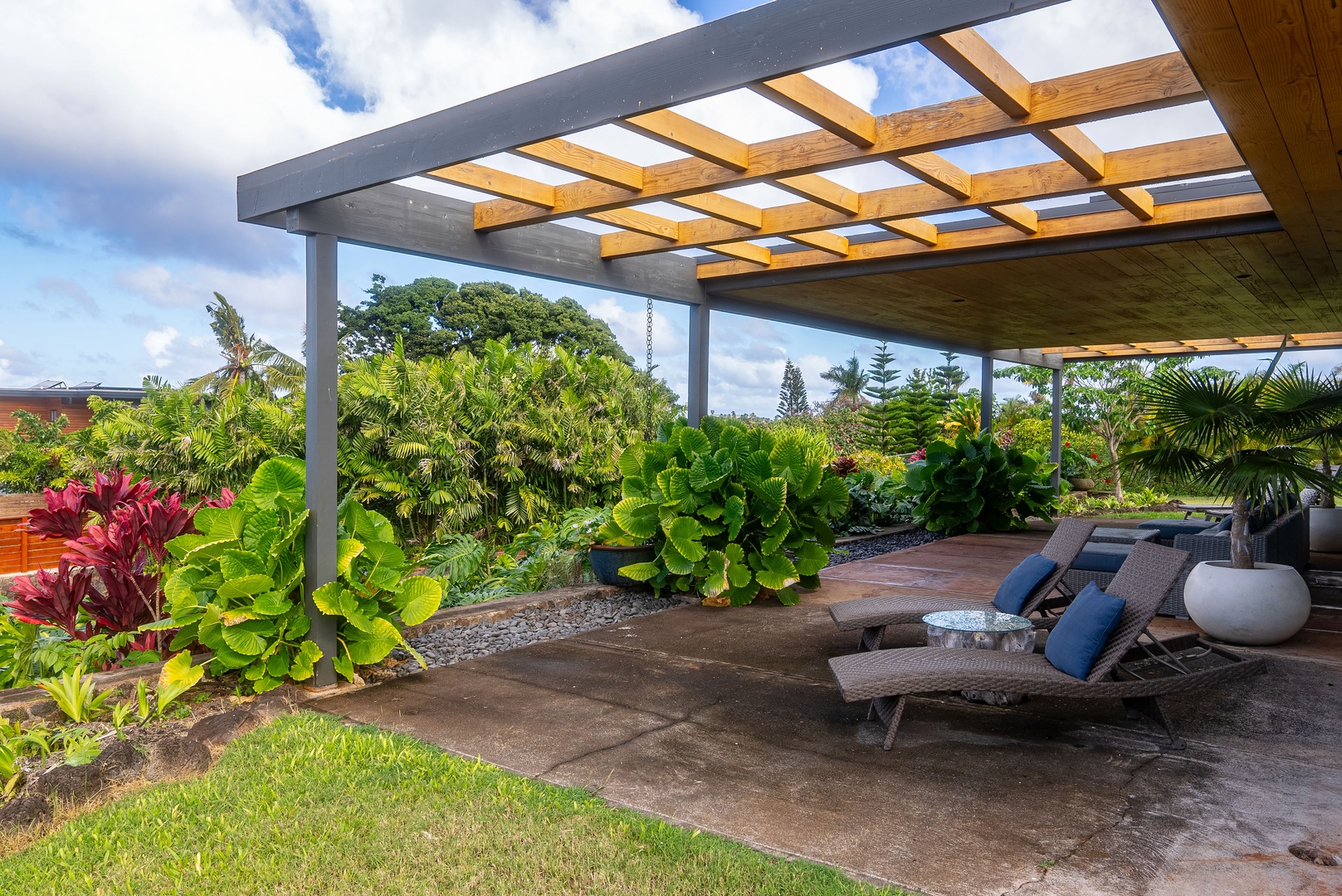 Haleiwa Vacation Rentals, Hale Mahina - Lounge under the pergola, surrounded by lush greenery and comfortable lounge seating for a peaceful outdoor retreat.