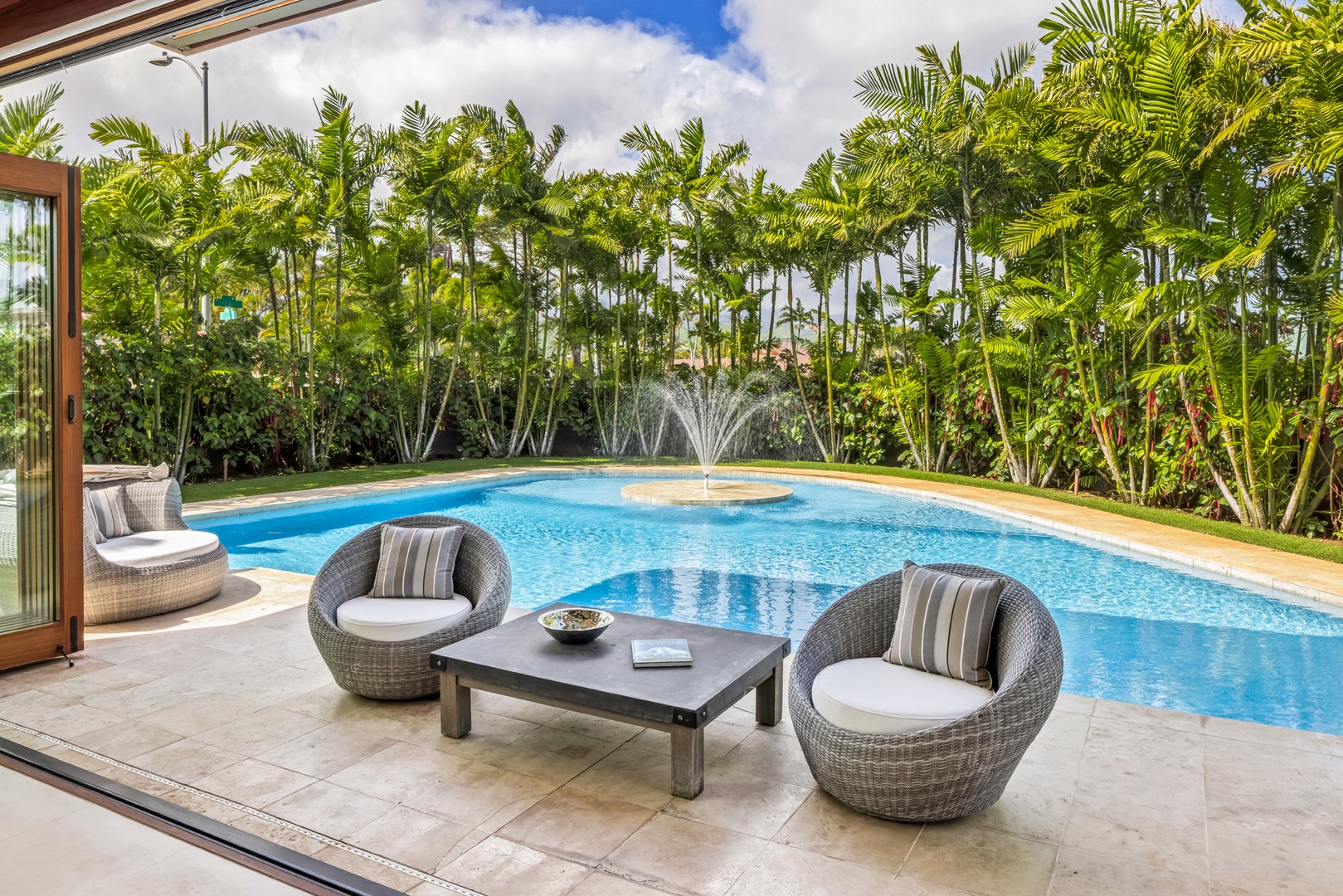 Honolulu Vacation Rentals, Kahala Grand Splendor - Unwind in the stylish poolside seating area, surrounded by lush greenery.