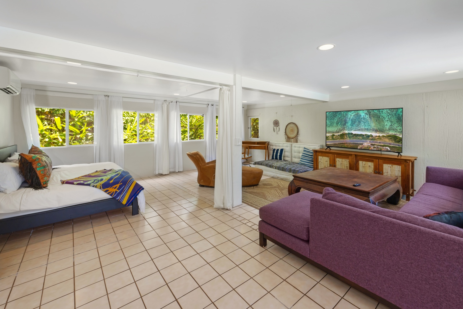 Kahuku Vacation Rentals, Hale Pellicano - The open-plan studio downstairs offers a comfortable living area with large TV, garden views and a king-sized bed.