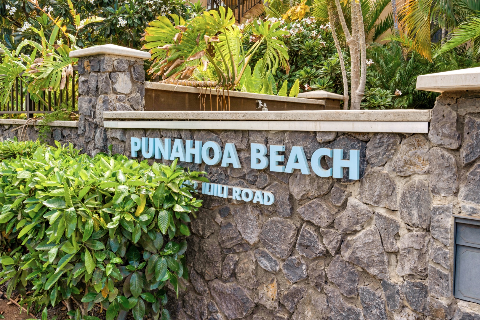 Kihei Vacation Rentals, Punahoa Beach 205 - The Punahoa Beach sign marks the turn off Iliili Road, framed by stone walls and greenery.