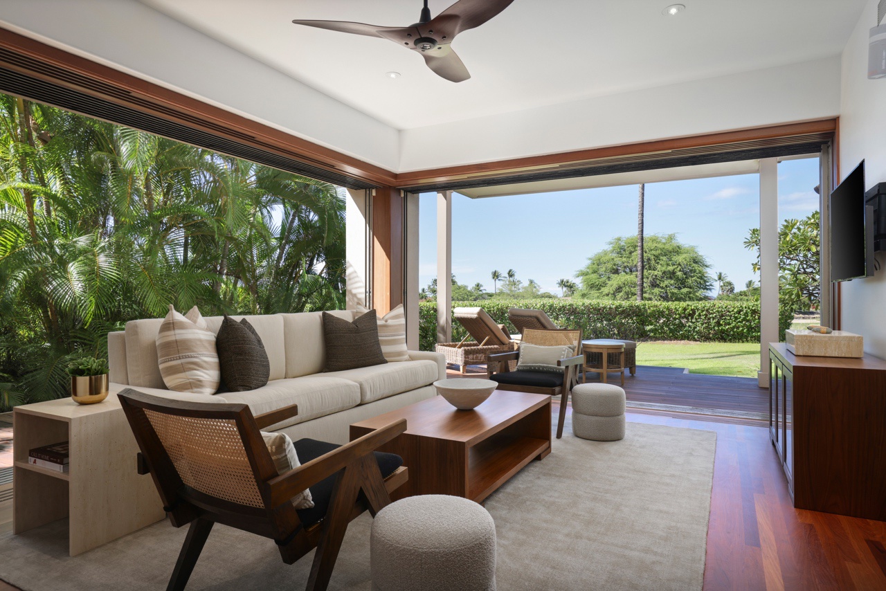 Kailua Kona Vacation Rentals, 3BD Ka'Ulu Villa (109A) at Hualalai Resort - Downstairs media room with plush furnishings, two corner walls of pocket doors, large deck, and manicured lawn beyond.