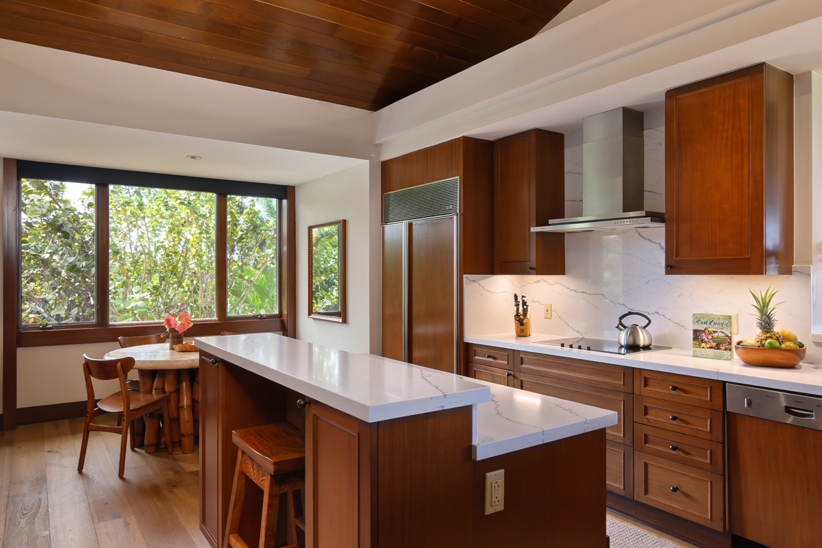 Kailua Kona Vacation Rentals, Fairways Villa 120A - Your gourmet kitchen features rich wood cabinetry and expansive countertops, perfect for preparing meals while enjoying garden views through large windows.