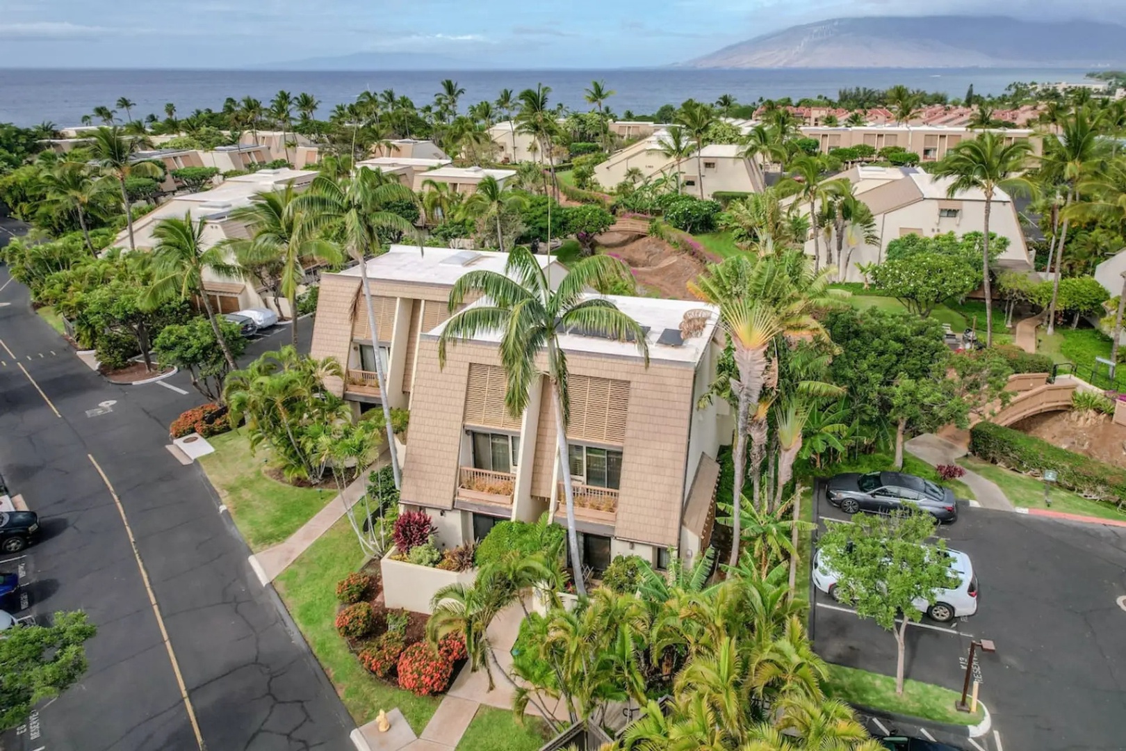Kihei Vacation Rentals, Maui Kamaole E103 - The A-frame building rises against the ocean and the West Maui mountains beyond it.