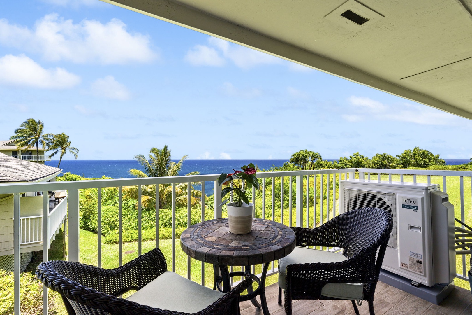 Princeville Vacation Rentals, Alii Kai 7201 - Dinner outside on the lanai, tropical green in front and the ocean past it.