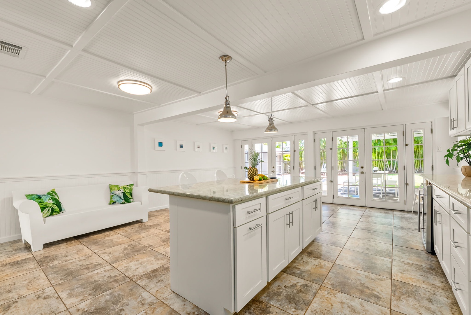 Honolulu Vacation Rentals, Ho'okipa Villa - Your bright, airy kitchen and lounge await—marble counters, tropical touches, and sunlight streaming through French doors to the patio.