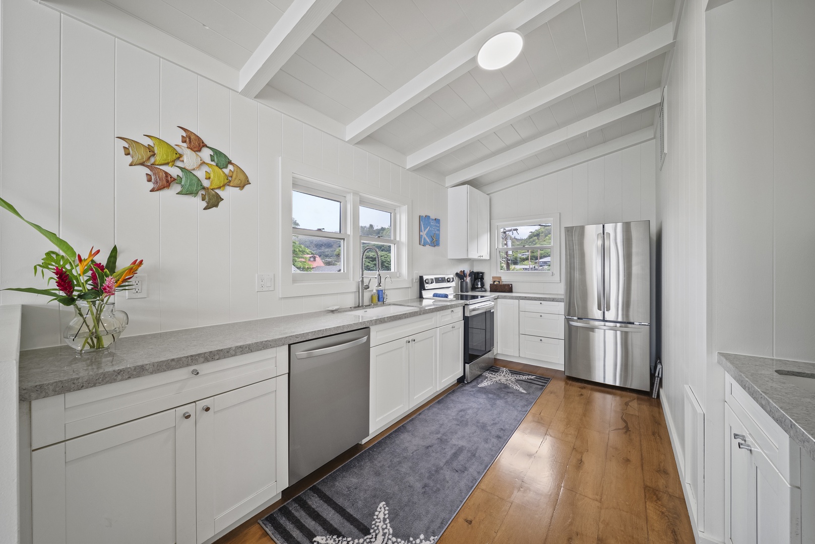 Haleiwa Vacation Rentals, Surfer's Paradise - Fully equipped galley-style kitchen featuring stainless steel appliances—perfect for preparing island-inspired meals together.