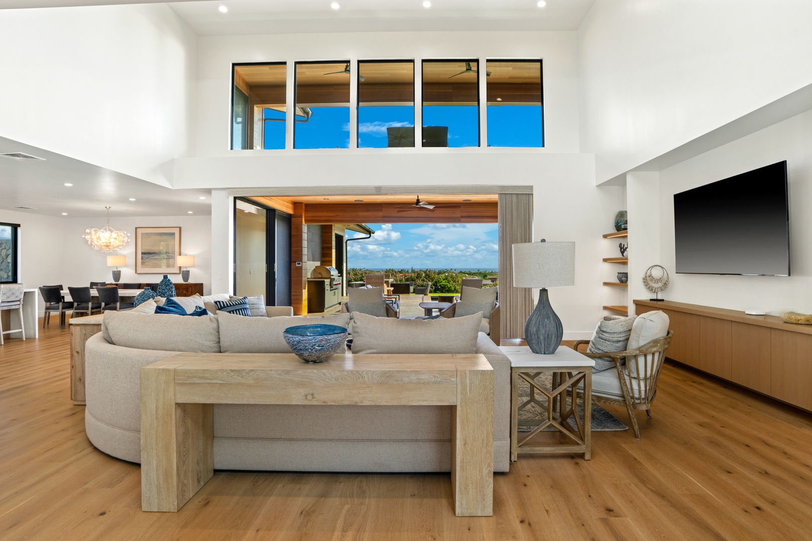 Koloa Vacation Rentals, Hale Laule'a at Kukui'ula - Unwind in your stylish living room where soaring ceilings and floor-to-ceiling windows create an airy sanctuary with stunning outdoor views.