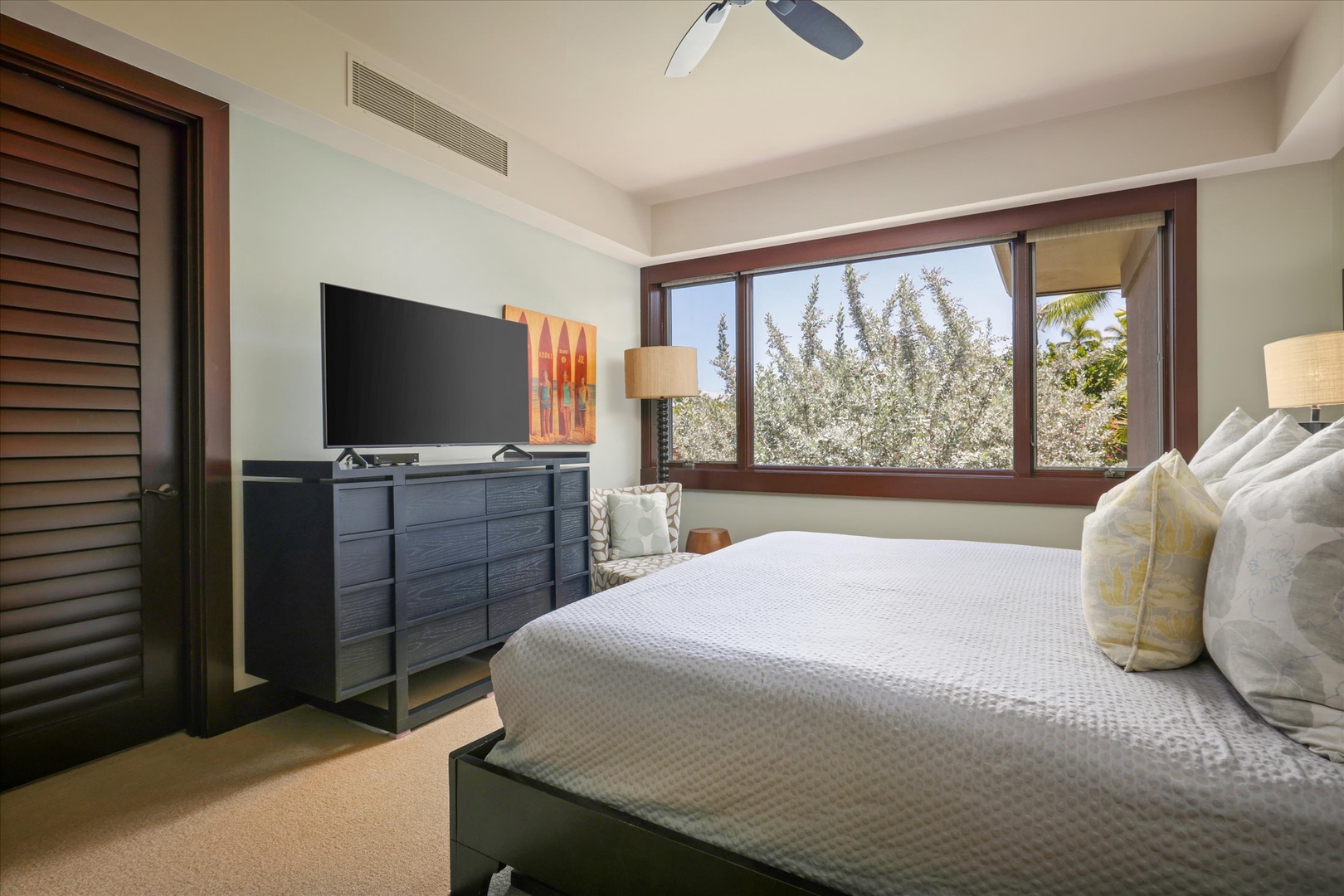 Kailua Kona Vacation Rentals, Wai'ulu Villa 115D - Guest bedroom with modern decor, garden views, and a wall-mounted TV—serene and stylish.