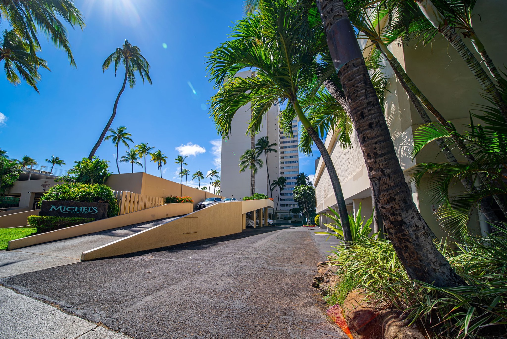 Honolulu Vacation Rentals, Hale Kaimana Breeze - Lush palm trees surround the property entrance for a tropical vibe.