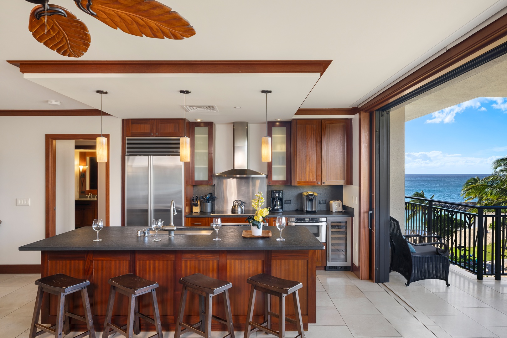 Kapolei Vacation Rentals, Ko Olina Beach Villas B506 - A Roy Yamaguci designed kitchen with stainless steel appliances and a cozy living room area.