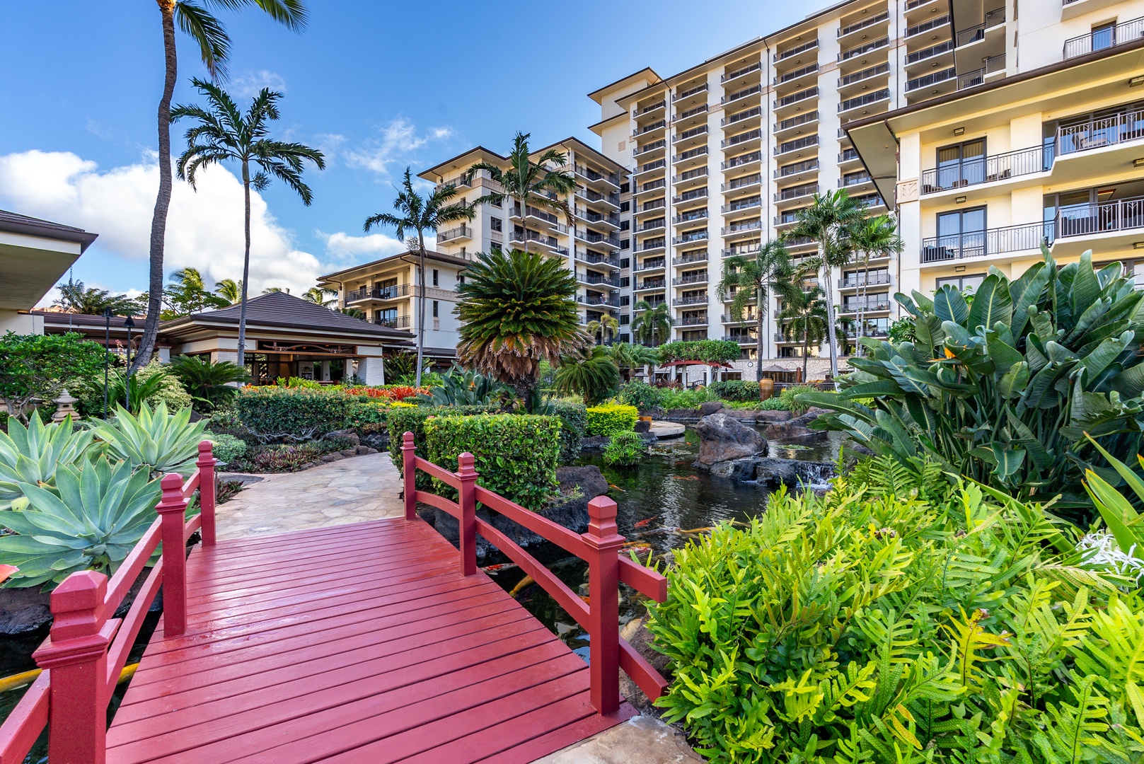 The red footbridge arches over the koi pond, part of the walk to the beach.